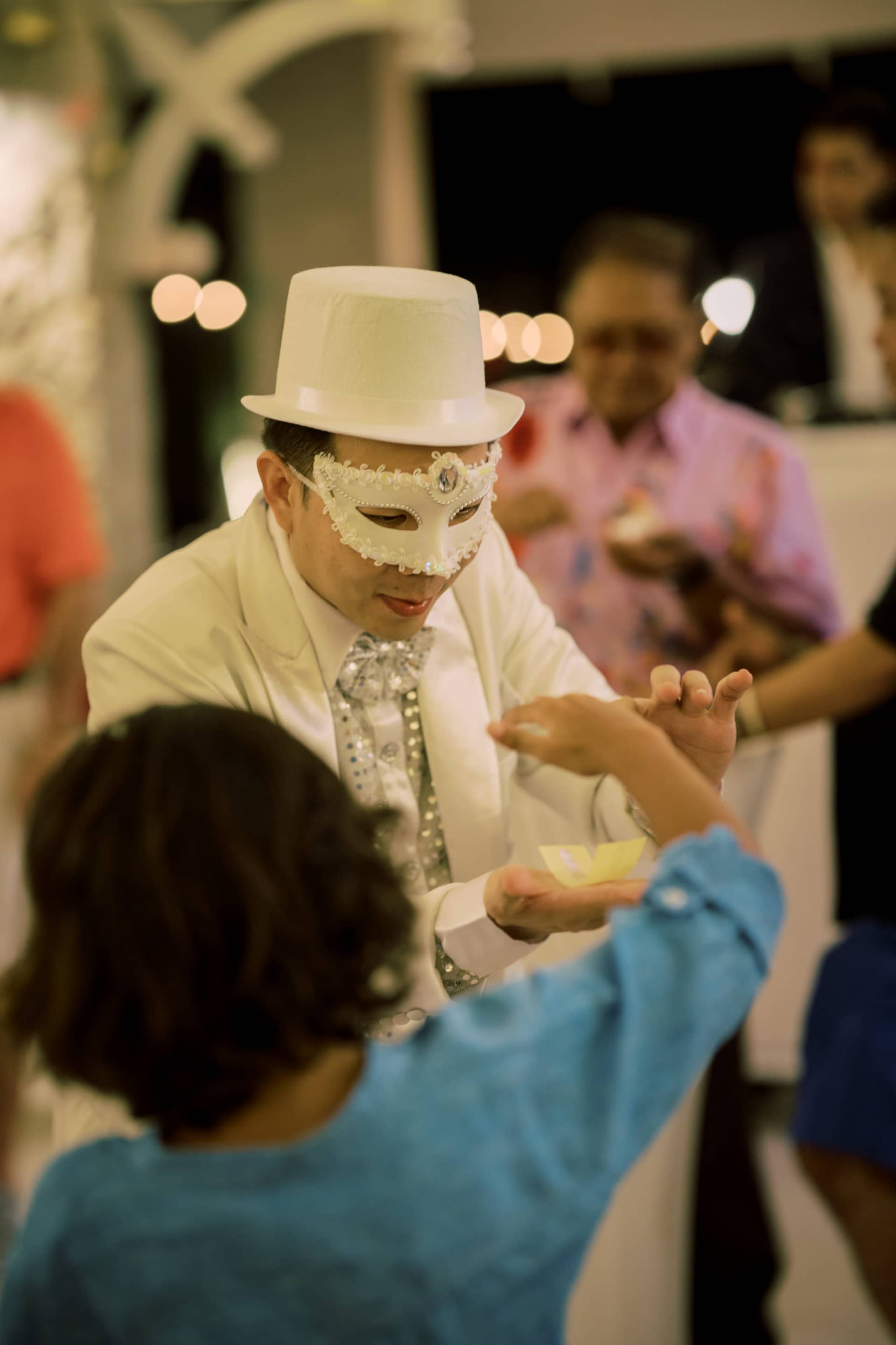 Parties And Events19 A man in a white hat and mask presents a piece of cake to a child, highlighting a joyful moment at event venues in Phuket.